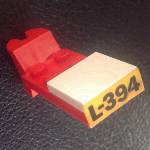 Деталь LEGO BA158pb01 Stickered Assembly 5 x 2 x 2/3 with Black 'L-394' on Yellow Background Pattern (Sticker) - Set 394 - 1 Tile 2 x 2, 1 Hinge Plate 2 x 4 Articulated