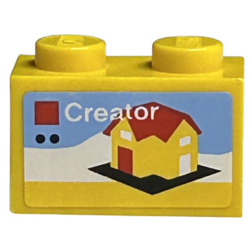 Деталь LEGO 3004pb221 Brick 1 x 2 with LEGO Creator Set Box Art, Yellow House with Red Roof and Door on Black Baseplate Pattern (Sticker) - Sets 40145 / 40305 and Gear 40359